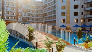 a bridge over a swimming pool in front of a building at Tiba Golden Resort in Hurghada +2 photos