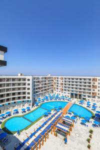 a large hotel with a pool and chairs and umbrellas at Tiba Golden Resort in Hurghada
