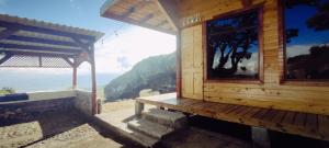 a porch of a wooden cabin with a view of the ocean at Hospedaje Jac Cabaña de Campo in Cartago
