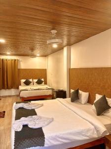 Baga Ocean Way في باغا: غرفة فندقية بها سريرين مع مناشف عليهما +56 صورة