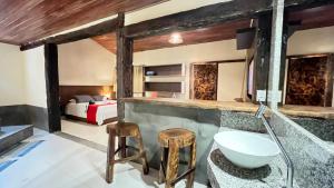 a bathroom with a sink and a bed at Pousada Flor de Pequi in Serra do Cipo