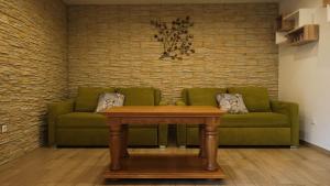 a living room with a green couch and a table at Hiša Lunna - Apartments in a Forest Paradise in Vitanje