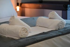 a pile of towels sitting on top of a bed at Pola's Cozy Apartment in Thessaloniki