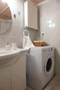 a bathroom with a washing machine and a sink at Pola's Cozy Apartment in Thessaloniki