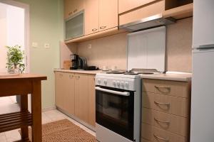 a kitchen with a stove top oven next to a table at Pola's Cozy Apartment in Thessaloniki