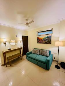 ein Wohnzimmer mit einem grünen Sofa und einem Schreibtisch in der Unterkunft ALOHA ON SACRED GANGES with INFINITY POOL in Rishikesh