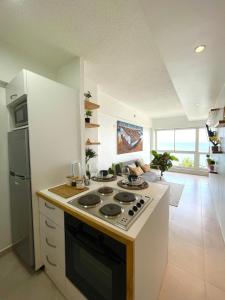 a kitchen with a stove top oven in a room at Ocean View. Acogedor Apartamento frente al mar in Porlamar +22 photos