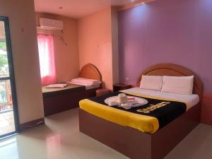 a bedroom with a bed with a plate of food on it at Rielena Plaza Hotel and Suites in Molave