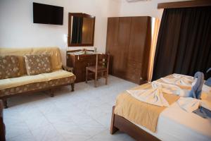 a hotel room with two beds and a desk and a chair at Nikos Studios in Kefalos