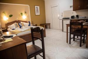 a kitchen and a living room with a couch and a table at Nikos Studios in Kefalos