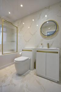 a white bathroom with a toilet and a mirror at Luxury Harborne Home, Perfect for Contractors & Families 5 Mins from QE & Uni in Birmingham
