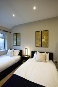 two beds sitting next to each other in a room at Luxury Harborne Home, Perfect for Contractors & Families 5 Mins from QE & Uni in Birmingham