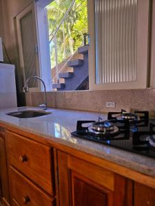 eine Küche mit einem Herd, einem Waschbecken und einem Fenster in der Unterkunft Melhor cervejaria do Brasil e a Serra te esperam! in Orleans