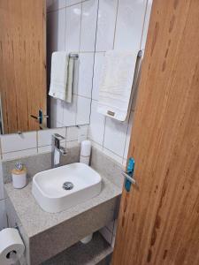ein Badezimmer mit einem weißen Waschbecken und einem Spiegel in der Unterkunft Melhor cervejaria do Brasil e a Serra te esperam! in Orleans + 1 Foto