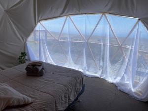 a bed in a tent with a large window at Vilos Domo excepcional domo privado in Los Vilos