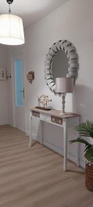 a room with a table with a mirror and a lamp at Solerma in Viveiro