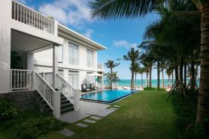 a house with a swimming pool next to the ocean at Premier Village Phu Quoc Resort Managed by Accor in Phu Quoc