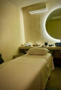 a bedroom with a bed with a mirror and a table at Central park lagunas in Tulum