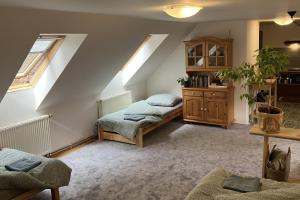 a attic room with two beds and a cabinet at Malé Labe - ubytování v podkroví in Prosečné