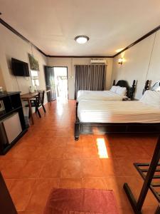 a hotel room with two beds and a television at Local Guesthouse in Vang Vieng