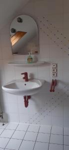 a white bathroom with a sink and a mirror at Ferienwohnung mit herrlichem Moselblick in Piesport +11 photos