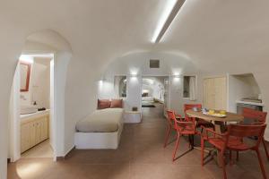 a kitchen and living room with a table and a bed at Blue Dolphins Apartments in Firostefani