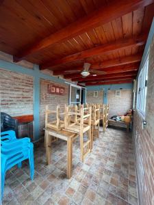 a patio with wooden chairs and a wooden ceiling at Hotel Altas Cumbres in Villa Carlos Paz