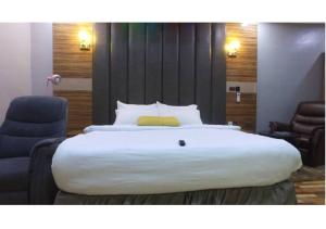 a large white bed in a hotel room at Grand Diamond Hotels & Suites LTD in Owerri