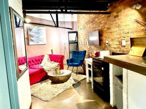 a living room with a red couch and blue chairs at Craftsmenship Loft in Johannesburg