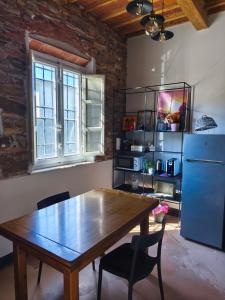a kitchen with a wooden table and a blue refrigerator at B&BIG LUCCA in Lucca