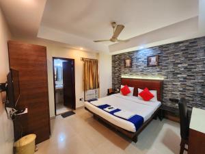 a bedroom with a bed with red pillows on it at Bhammar's Inn - A Pure Veg in Kolkata