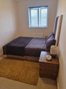 a bedroom with a bed and a table and a window at Lovely and Cosy Double Room in Havering atte Bower
