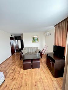 a living room with a couch and a tv at Хотел Валентино 2 in Dobrinishte +7 photos