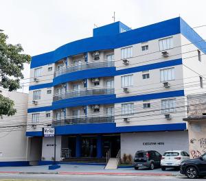 a blue and white building with cars parked in front of it at Inter Hotel in Vitória