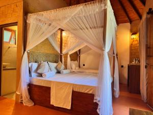 a bedroom with a canopy bed with white mosquito nets at The Cottage Negombo in Kochchikade +30 photos