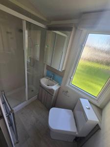 a bathroom with a toilet and a sink and a shower at Haven Burnham on sea 16 Elm Grove in Burnham on Sea