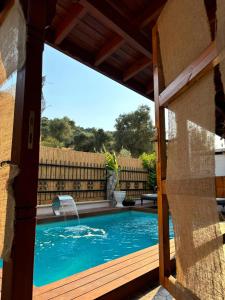 une piscine vue par une fenêtre d'une maison dans l'établissement Milas-Bodrum Özel Havuzlu Triplex Villa, à Milas