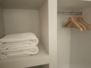 a bathroom with white towels on a shelf at Mary's Cozy apartment in Alexandroupoli +12 photos
