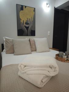 a bed with a white blanket on top of it at Mary's Cozy apartment in Alexandroupoli