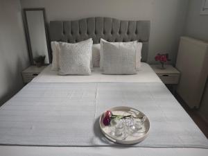 a plate with flowers in it on a bed at Mary's Cozy apartment in Alexandroupoli