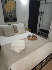 a bed with a tray of towels on it at Mary's Cozy apartment in Alexandroupoli