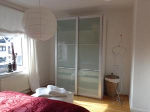 a bedroom with a large glass closet with a dresser at Wohnen&Wellness Kurgartenstrasse in Travemünde