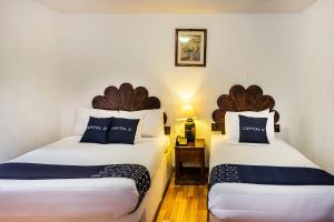 Dos camas en una habitación de hotel con dos plazas. en Capital O Hotel Central, Xalapa, en Xalapa