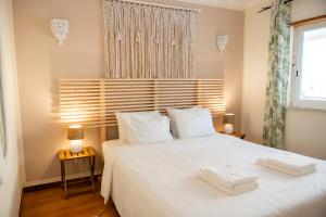 a bedroom with a white bed with two towels on it at Old Town Boho Seaview Elegance in Albufeira +68 photos