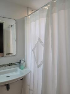 a bathroom with a white shower curtain and a sink at Los Naranjos in San Salvador de Jujuy