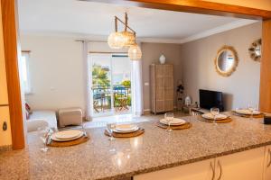 a kitchen with a counter with a table with wine glasses at Old Town Boho Seaview Elegance in Albufeira