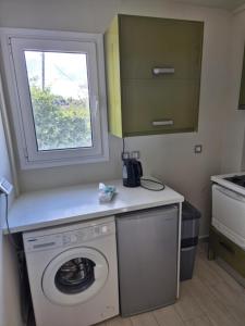 a washing machine in a kitchen with a window at tzogias apartments nonna studio in Lassi +28 photos