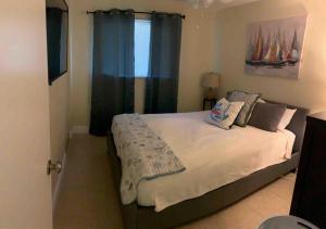 a bedroom with a large bed with blue curtains at Great 4b2b getaway with heated salt water pool in Fort Lauderdale