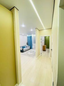 a living room with a couch and a hallway at Syganak Apartments in Astana