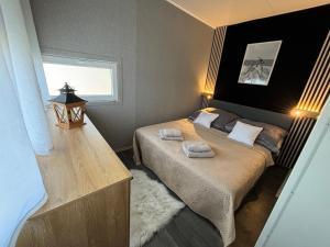 a bedroom with a bed with two towels on it at rishko resort - Lake View - free Parking - 24hr Self chceck-in - Serviced Apartment Premium by Hotelstars Union in Holčíkovce